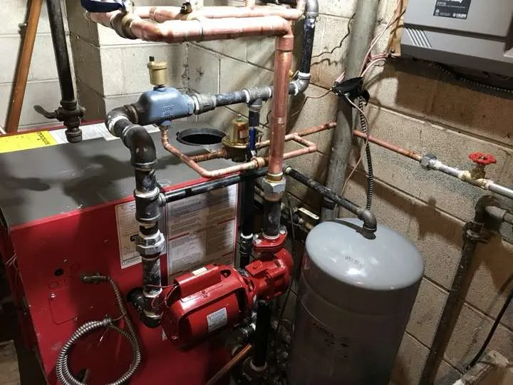 Boiler installation with circulation pumps and copper piping in a residential basement