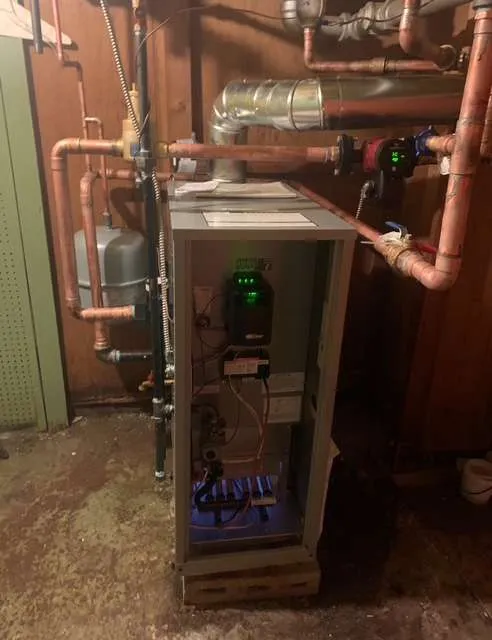 High-efficiency boiler installation with copper piping and digital controls in a home basement
